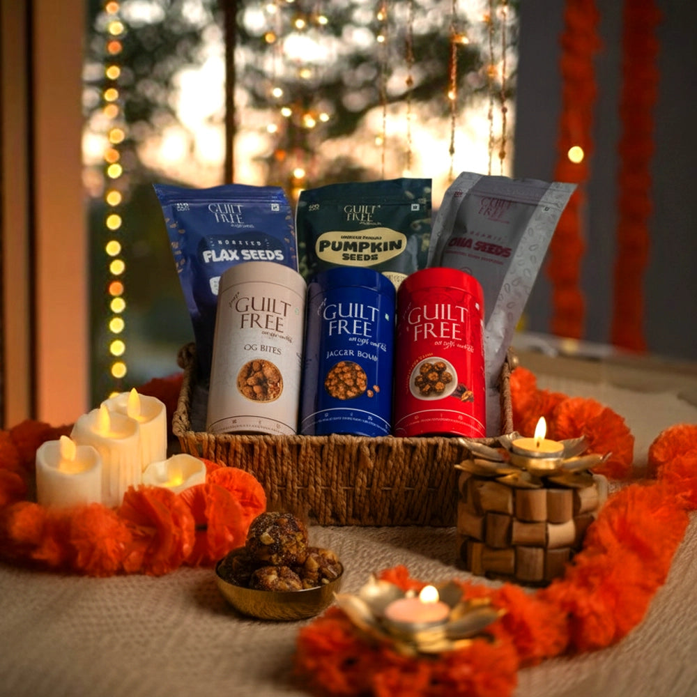 Basket of 'Guilt Free' snack packages with decorative candles and flowers on a festive background.