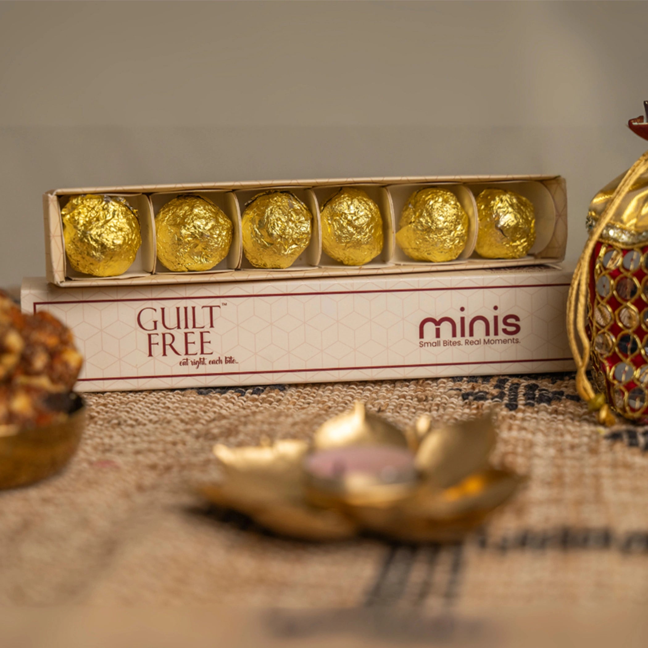 Box of gold-wrapped  with 'minis' branding on a textured surface.